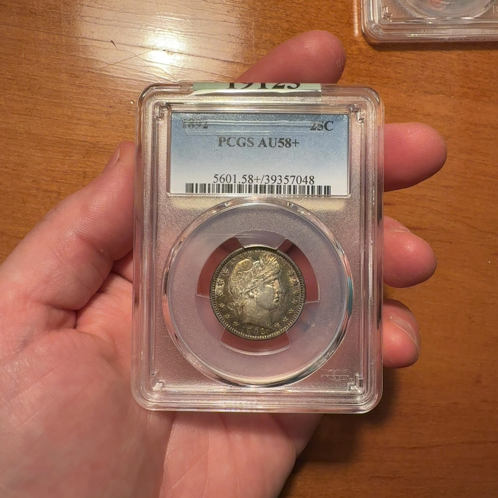 Additional handheld reference photograph 1 of the same 1892 quarter · PCGS AU58+