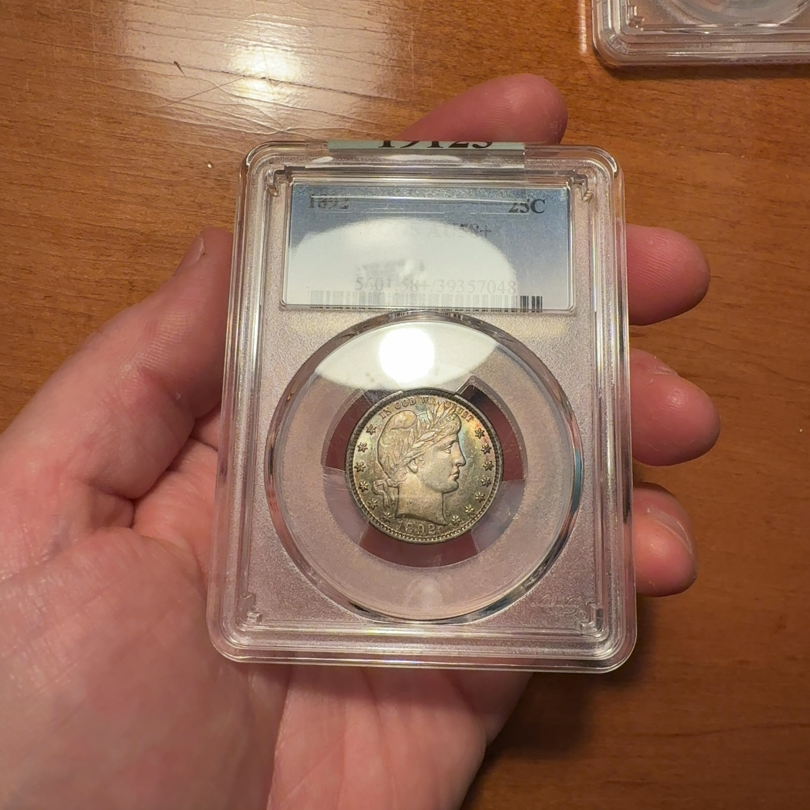 Additional handheld reference photograph 2 of the same 1892 quarter · PCGS AU58+